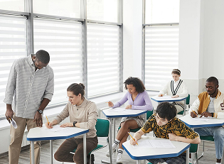 Enseignant aidant une étudiante en classe illustre la vision pédagogique de NEO RH Campus