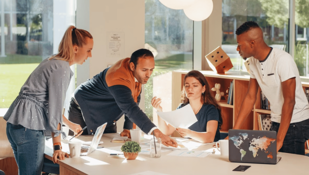 Démarche QVCT : une équipe échange autour de documents de travail dans un espace lumineux