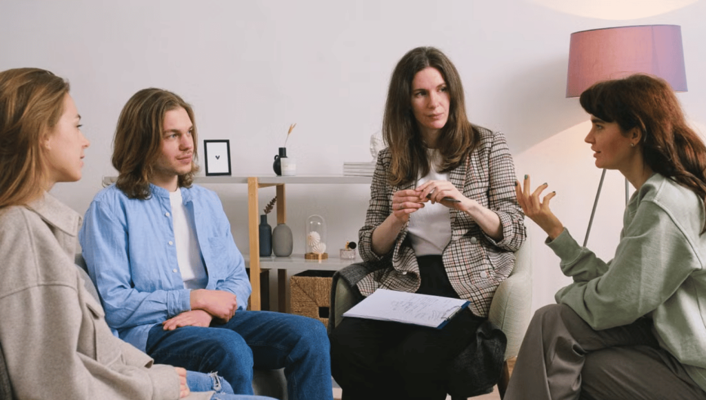 Un groupe de travail échange en cercle sur les risques psychosociaux, l'animatrice prenant des notes sur son porte-bloc